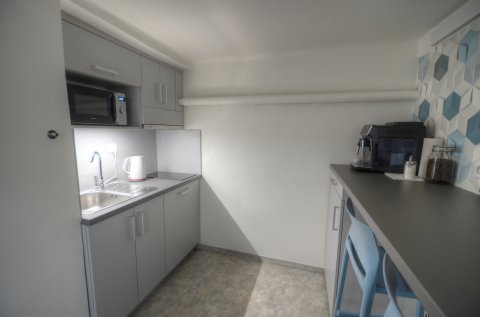 Kitchen with coffee machine, fridge, microwave, and nice bar seating